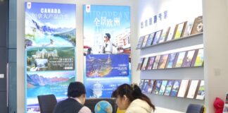 北京旅行社職員與旅客討論前往加拿大旅遊安排