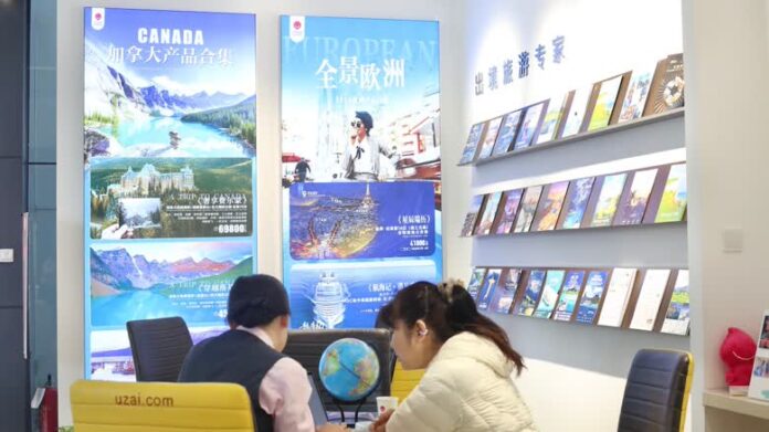 北京旅行社職員與旅客討論前往加拿大旅遊安排