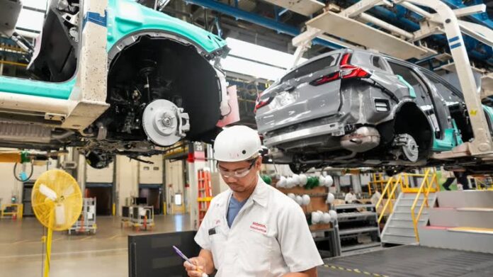 Honda 工廠員工在汽車裝配線旁工作