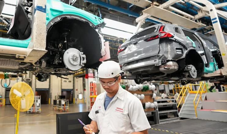 Honda 工廠員工在汽車裝配線旁工作