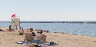 多倫多湖濱泳灘夏季開放，有泳客在沙灘休息，附近設有救生員崗位。