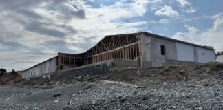 An old wooden building with part of the front torn off.