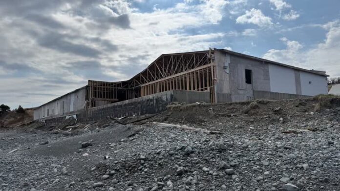 An old wooden building with part of the front torn off.