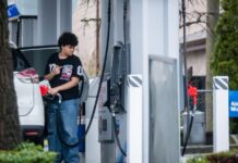 加拿大油站有司機為汽車加油，油價牌顯示每公升超過2元。
