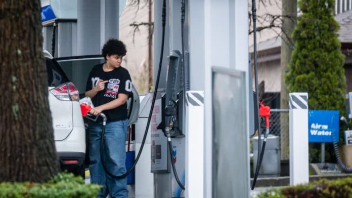 加拿大油站有司機為汽車加油，油價牌顯示每公升超過2元。