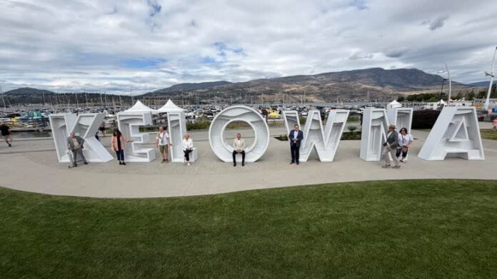 Kelowna 湖畔新字牌在 Stuart Park 亮相，市議員坐在字母中拍照。