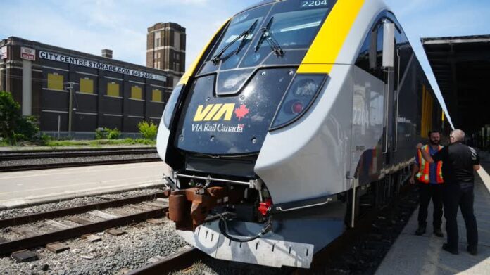 兩名男子站在月台旁，身後是一列客運列車。