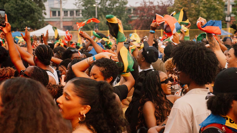 Wi Deh’Ya活動參加者揮動不同加勒比地區旗幟。