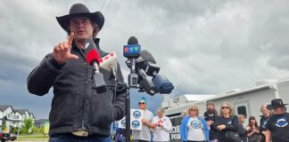 Corb Lund 在 Elections Alberta 辦公室外向傳媒發言，配合 Water Not Coal 請願被拒報道。