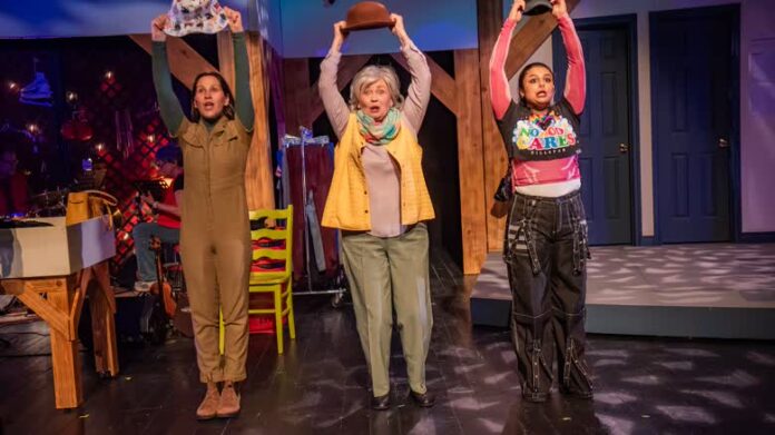 Frenchy’s: The Thrift Musical 演員在台上手持帽子演唱。