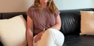 卡加利教師 Kristy Moore 站在住宅前，反映加拿大旅客以家居交換節省旅費。