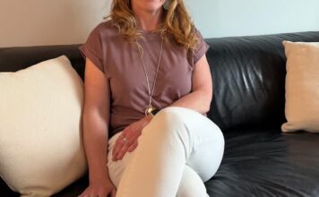 卡加利教師 Kristy Moore 站在住宅前，反映加拿大旅客以家居交換節省旅費。