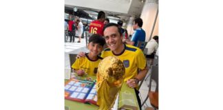 Burnaby 父子 Christian Pazmino 與 8 歲兒子 Felipe 在貼紙交換聚會上展示世界盃相簿。