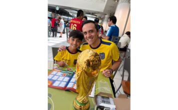 Burnaby 父子 Christian Pazmino 與 8 歲兒子 Felipe 在貼紙交換聚會上展示世界盃相簿。