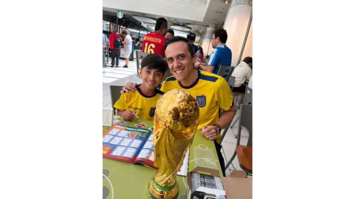 Burnaby 父子 Christian Pazmino 與 8 歲兒子 Felipe 在貼紙交換聚會上展示世界盃相簿。