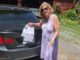 Nancy Griffin 手持停車罰單站在找回的車旁。