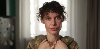 This officer with the National Guard of Ukraine goes by the call sign 'Kudriava.' She was issued standard body armour designed for men, but over the years she's bought her own because it fits better. (Serhii Moos/CBC)