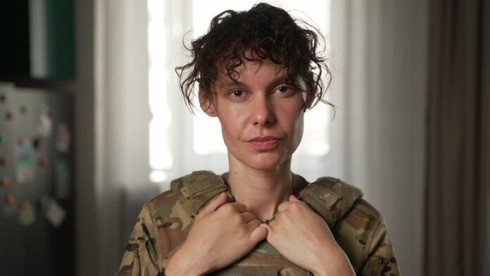 This officer with the National Guard of Ukraine goes by the call sign 'Kudriava.' She was issued standard body armour designed for men, but over the years she's bought her own because it fits better. (Serhii Moos/CBC)