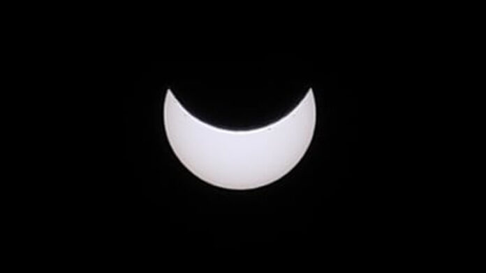 A black sky with a bright white moon.