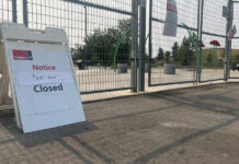 A closure sign in front of a fenced off splash pad