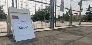 A closure sign in front of a fenced off splash pad