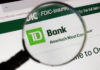 A magnifying glass over a TD Bank logo on a computer screen.