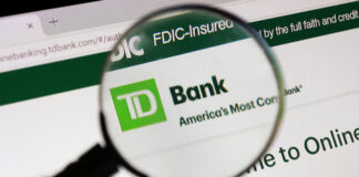 A magnifying glass over a TD Bank logo on a computer screen.