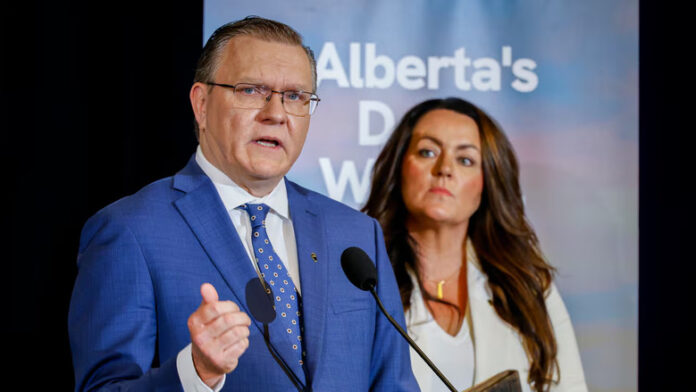 A man and a woman speak at a podium.