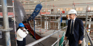 Prime Minister Mark Carney looks over a 212A class submarine under maintenance as he tours the ThyssenKrupp Marine Systems submarine-building facility in Kiel, Germany, in August 2025. (Christinne Muschi/The Canadian Press)