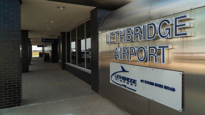 A dark hallway features a large wall sign that reads "Lethbridge Airport."