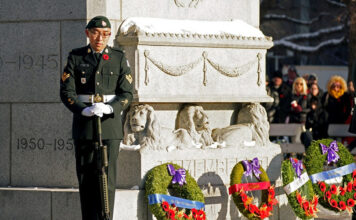 Morgan Xishen Wong stands guard at the cenotaph in front of Edmonton City Hall during a Remembrance Day ceremony on Nov. 11, 2022. Photo by Larry Wong / Postmedia