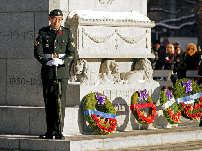 Morgan Xishen Wong stands guard at the cenotaph in front of Edmonton City Hall during a Remembrance Day ceremony on Nov. 11, 2022. Photo by Larry Wong / Postmedia